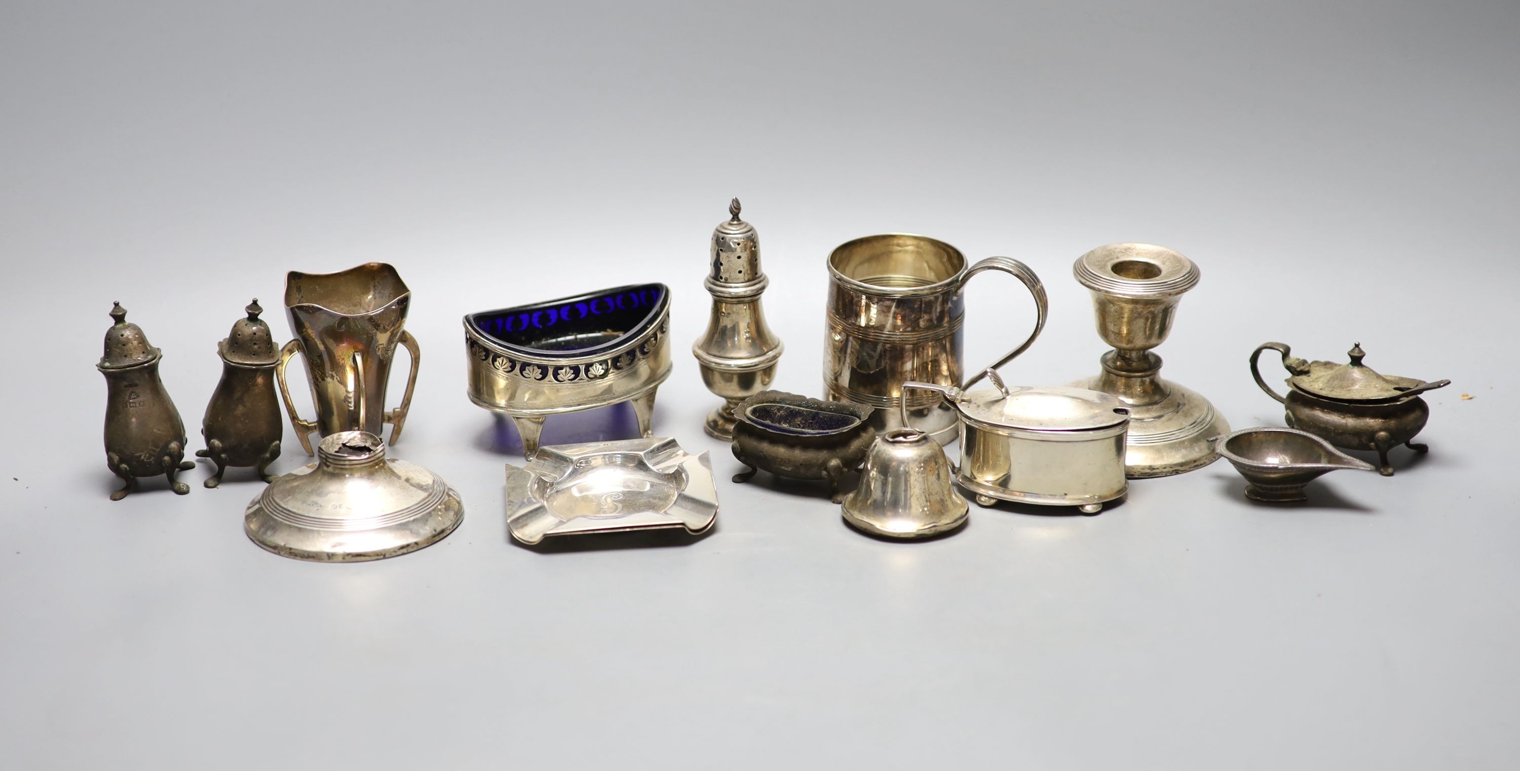 A mixed group of sundry small silver and other items including a pair of silver ashtrays, a small silver vase, silver pepper, damaged dwarf candlesticks, plated mug etc.